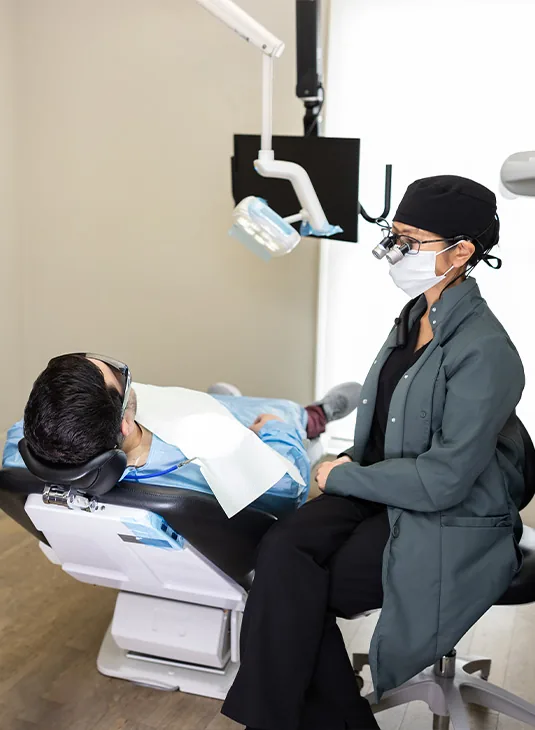 Clinician seated beside a patient in a treatment room at Signature Smiles Studio in Decatur, GA