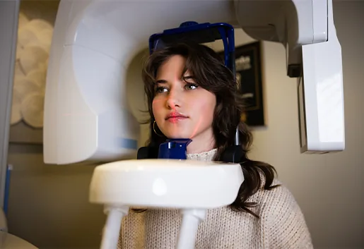 Patient seated in the panoramic and CBCT imaging machine with the head positioner in place