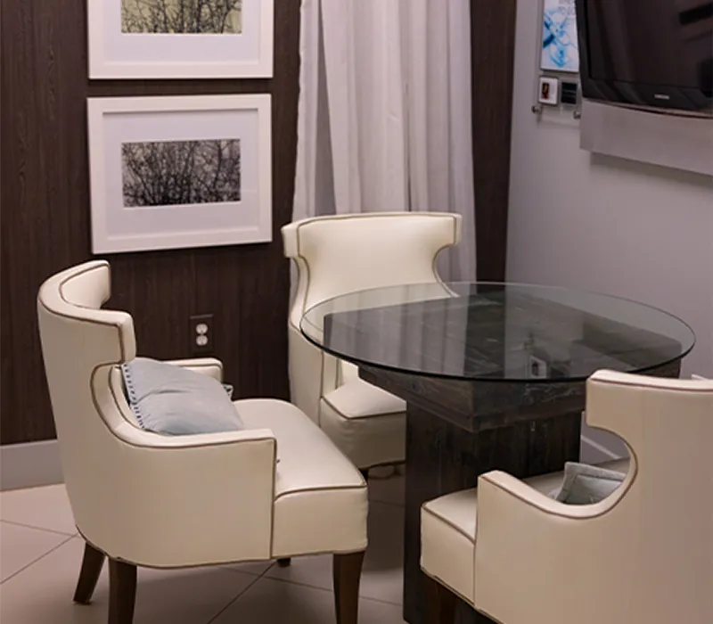 Consultation nook with two cream armchairs and a round glass table